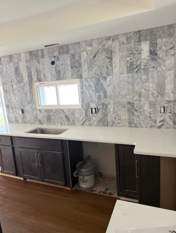 Calacatta marble bathtub surround with dark hardwood floor in Northbrook home