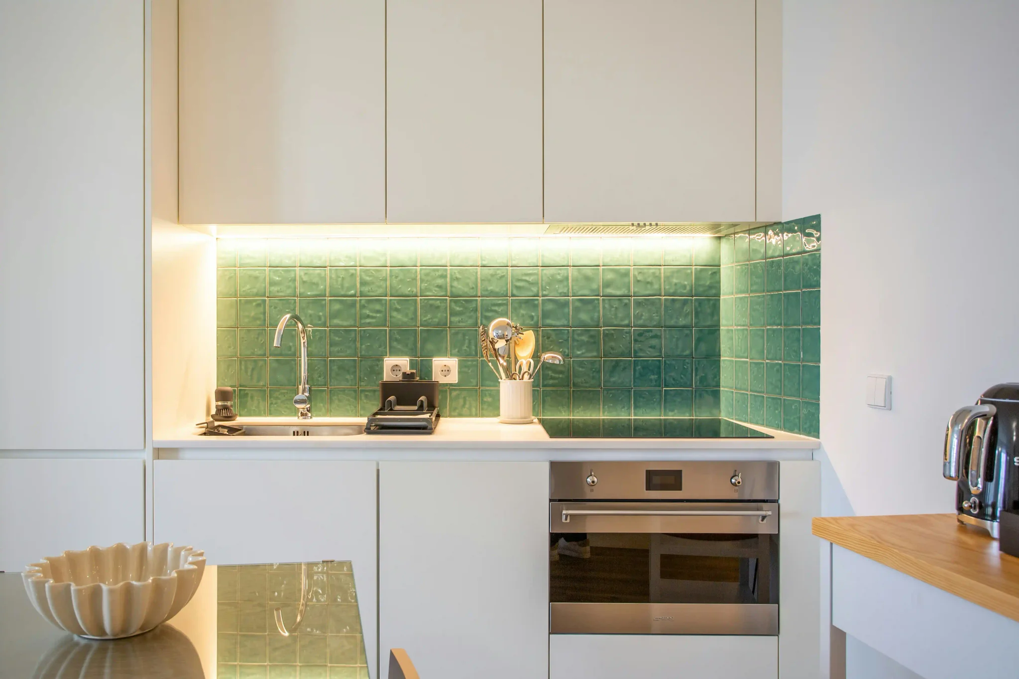 Glossy green zellige kitchen backsplash with warm LED lighting installed by Northbrook Tile Installer