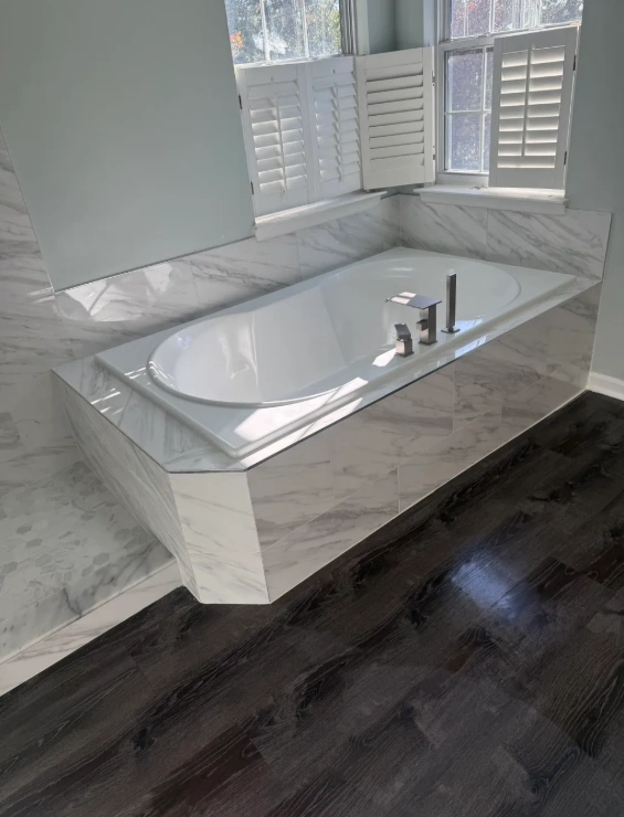 Kitchen bar island clad in dark stone mosaic tile with custom LED lighting in a Northbrook home